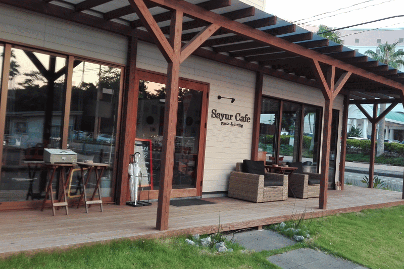ウッドデッキの茶色と芝生の緑が素敵な落ち着いた雰囲気のカフェです